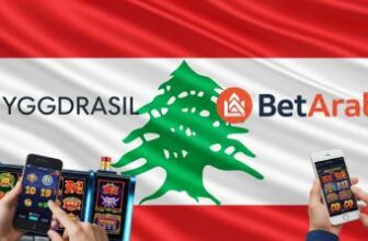 Yggdrasil and BetArabia logos over Lebanese flag with mobile slot gameplay, representing regulated iGaming launch in Lebanon.